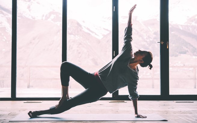 Frau in einem Yogastudio mit Aussicht auf die Berge