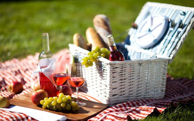 Im Picknick-Korb ist alles gut verstaut: Decke, Brettchen, Servietten, Obst, Wein und Baguette